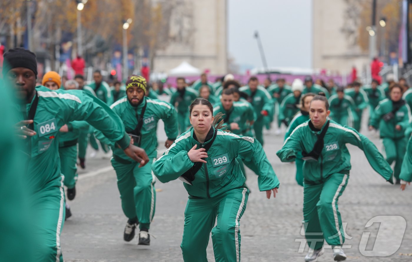 본문 이미지 - 1일(현지시간) 프랑스 파리 샹젤리제 거리에서 열린 넷플릭스 오리지널 시리즈 ‘오징어게임’ 재현 현장 이벤트에서 참가자들이 드라마 속 게임인 ‘무궁화꽃이 피었습니다’에 참여하고 있다.  2024.12.2/뉴스1 ⓒ News1 이준성 기자