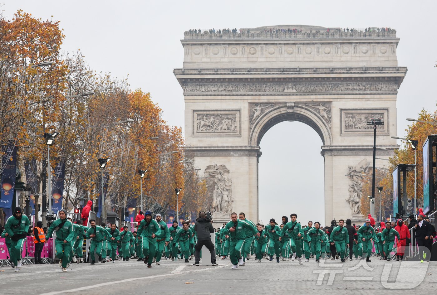본문 이미지 - 11일(현지시간) 프랑스 파리 샹젤리제 거리에서 열린 넷플릭스 오리지널 시리즈 ‘오징어게임’ 재현 현장 이벤트에서 참가자들이 드라마 속 게임인 ‘무궁화꽃이 피었습니다’에 참여하고 있다.  2024.12.2/뉴스1 ⓒ News1 이준성 기자