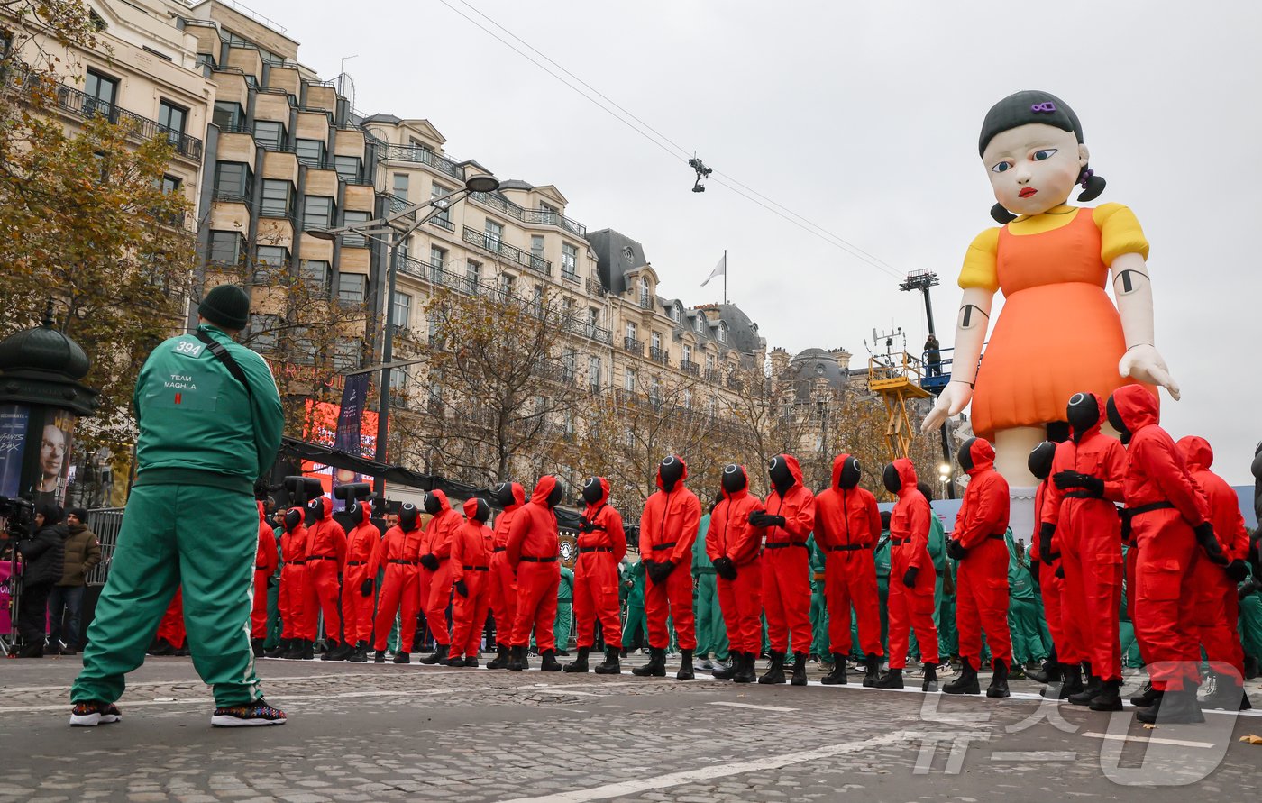본문 이미지 - 1일(현지시간) 프랑스 파리 샹젤리제 거리에서 열린 넷플릭스 오리지널 시리즈 ‘오징어게임’ 재현 현장 이벤트에서 참가자들이 드라마 속 게임인 ‘무궁화꽃이 피었습니다’에 참여하고 있다.  2024.12.2/뉴스1 ⓒ News1 이준성 기자