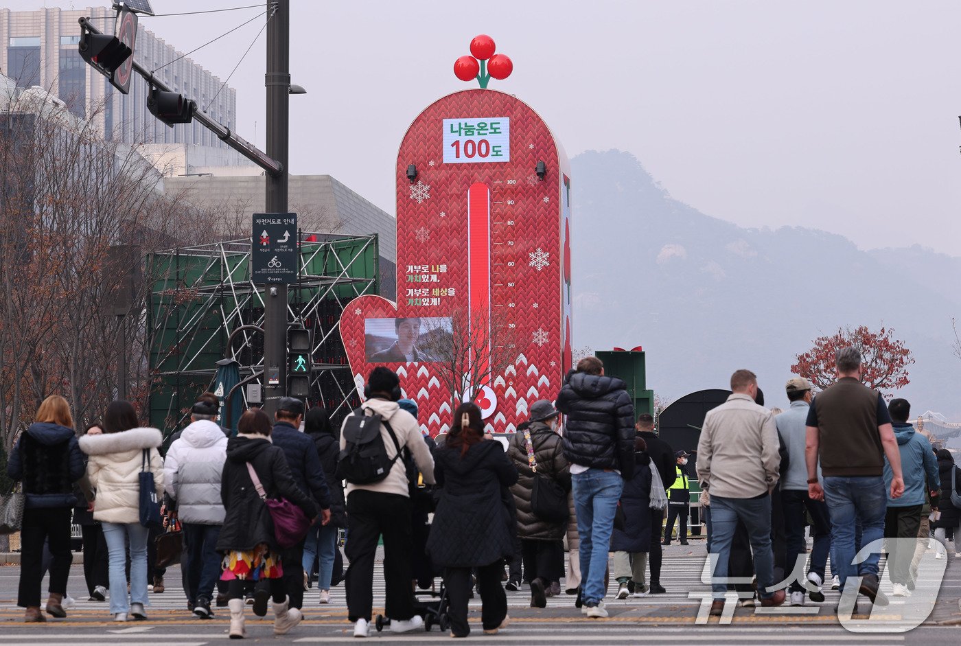 본문 이미지 - 2일 서울 광화문광장에 점등된 사랑의 온도탑 앞으로 시민들이 지나가고 있다. 사랑의열매 사회복지공동모금회가 12월을 맞아 연말연시 이웃돕기캠페인인 '희망2025 나눔캠페인'에 나섰다. 지난해보다 3.4% 가량 높은 4497억 원을 모금목표액으로 삼은 가운데 앞으로 두 달 간 진행되는 캠페인을 통해 기부와 나눔 문화를 확산하겠다는 방침이다. 2024.12.2/뉴스1 ⓒ News1 박지혜 기자