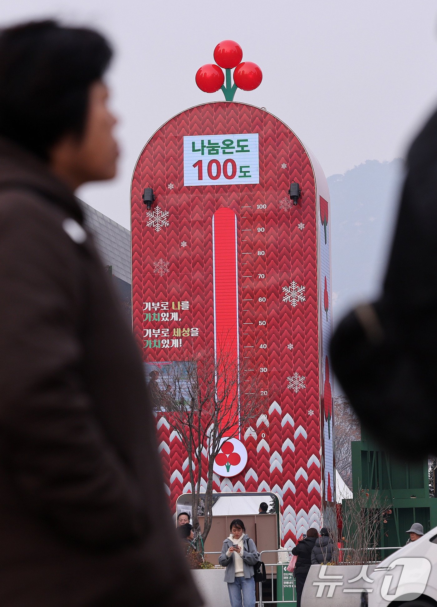 본문 이미지 - 2일 서울 광화문광장에 점등된 사랑의 온도탑 앞으로 시민들이 지나가고 있다. 사랑의열매 사회복지공동모금회가 12월을 맞아 연말연시 이웃돕기캠페인인 '희망2025 나눔캠페인'에 나섰다. 지난해보다 3.4% 가량 높은 4497억 원을 모금목표액으로 삼은 가운데 앞으로 두 달 간 진행되는 캠페인을 통해 기부와 나눔 문화를 확산하겠다는 방침이다. 2024.12.2/뉴스1 ⓒ News1 박지혜 기자