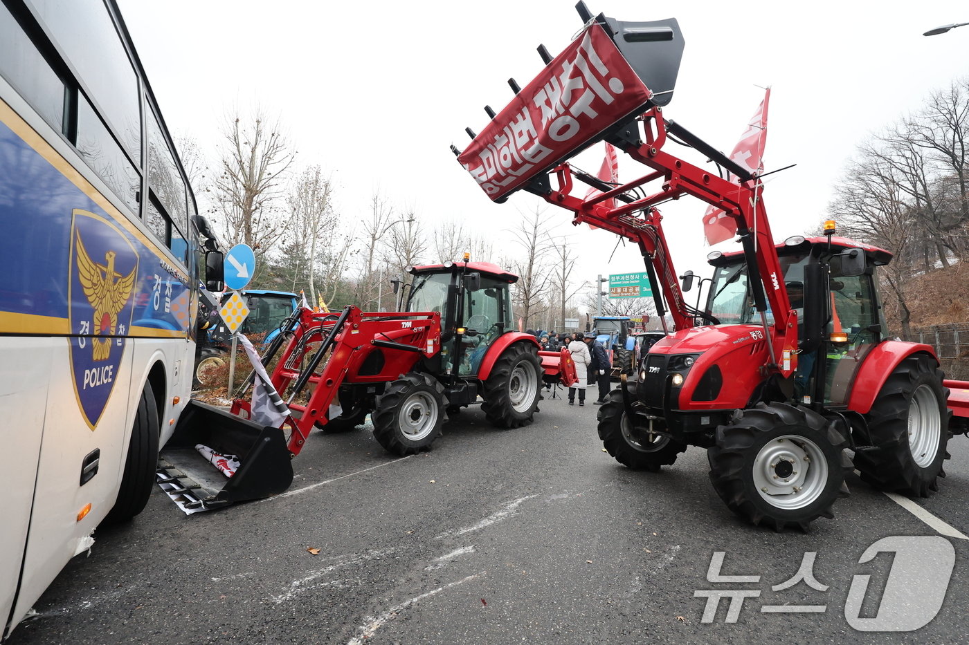 본문 이미지 - 전국농민회총연맹 전봉준 투쟁단 농민들이 21일 윤석열 대통령 구속 등을 촉구하는 집회를 위해 트랙터와 트럭을 몰고 상경하던 중 서울 남태령 고개 인근에서 경찰병력과 대치하고 있다. 2024.12.21/뉴스1 ⓒ News1 이동해 기자