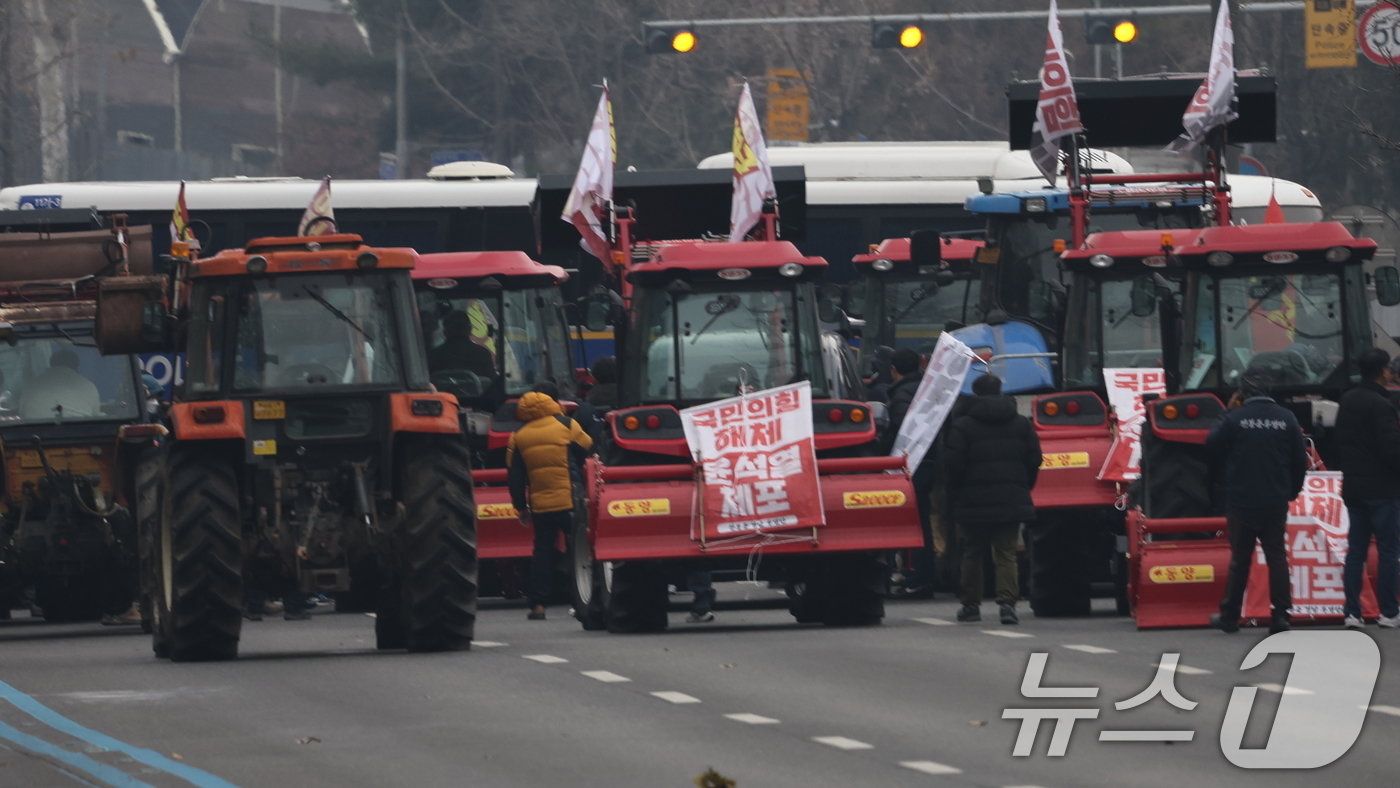 본문 이미지 - 전국농민회총연맹 전봉준 투쟁단 농민들이 21일 윤석열 대통령 구속 등을 촉구하는 집회를 위해 트랙터와 트럭을 몰고 상경하던 중 서울 남태령 고개 인근에서 경찰병력과 대치하고 있다. 2024.12.21/뉴스1 ⓒ News1 이동해 기자