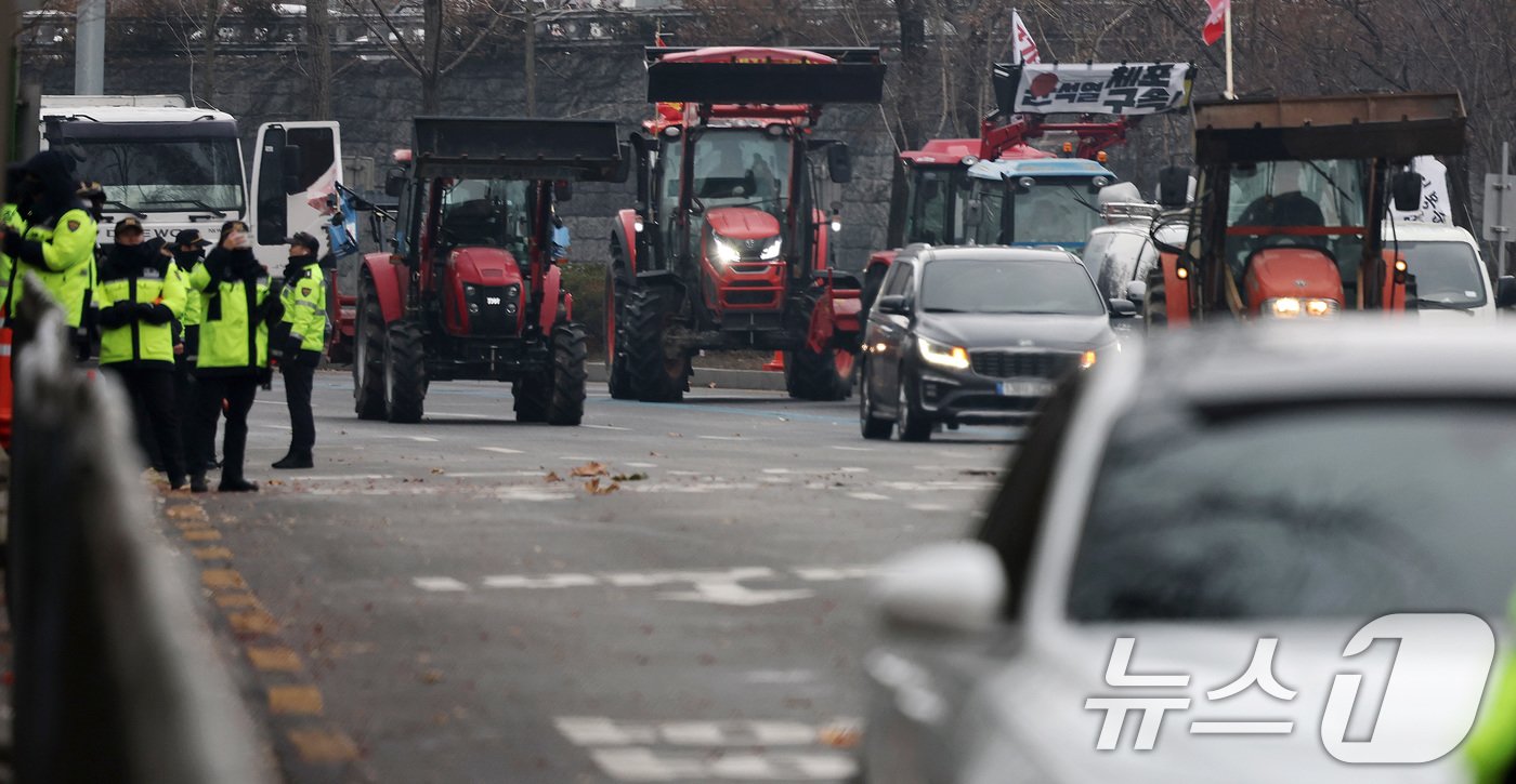 본문 이미지 - 전국농민회총연맹 전봉준 투쟁단 농민들이 21일 윤석열 대통령 구속 등을 촉구하는 집회를 위해 트랙터와 트럭을 몰고 상경하던 중 서울 남태령 고개 인근에서 경찰병력과 대치하고 있다. 2024.12.21/뉴스1 ⓒ News1 이동해 기자