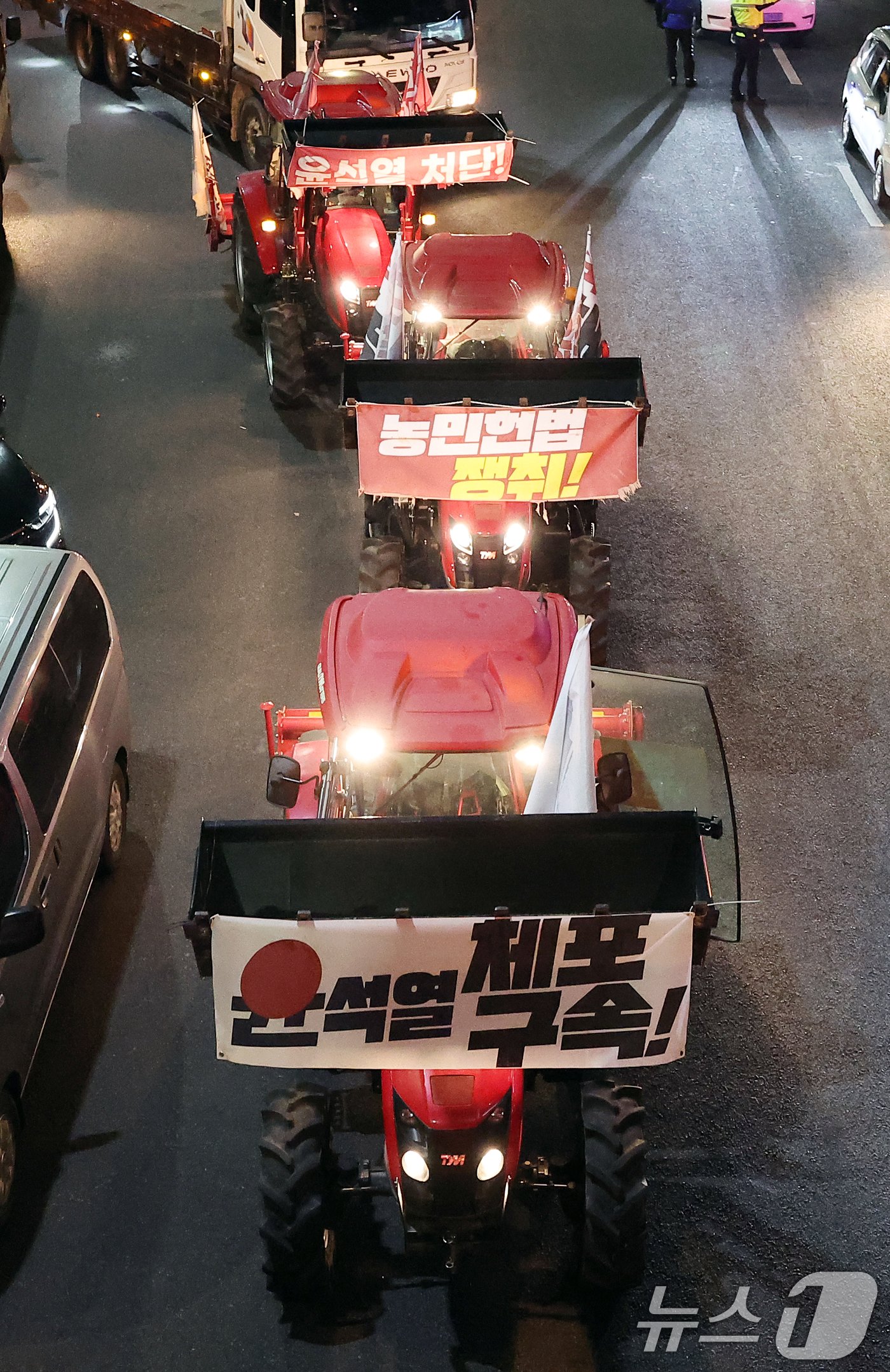 본문 이미지 - 전국농민회총연맹(전농)의 트랙터들이 22일 오후 서울 서초구 남태령에서 윤석열 대통령 구속을 촉구하는 집회를 갖은 뒤 대통령 한남관저 앞에 정차하고 있다. 2024.12.22/뉴스1 ⓒ News1 김진환 기자