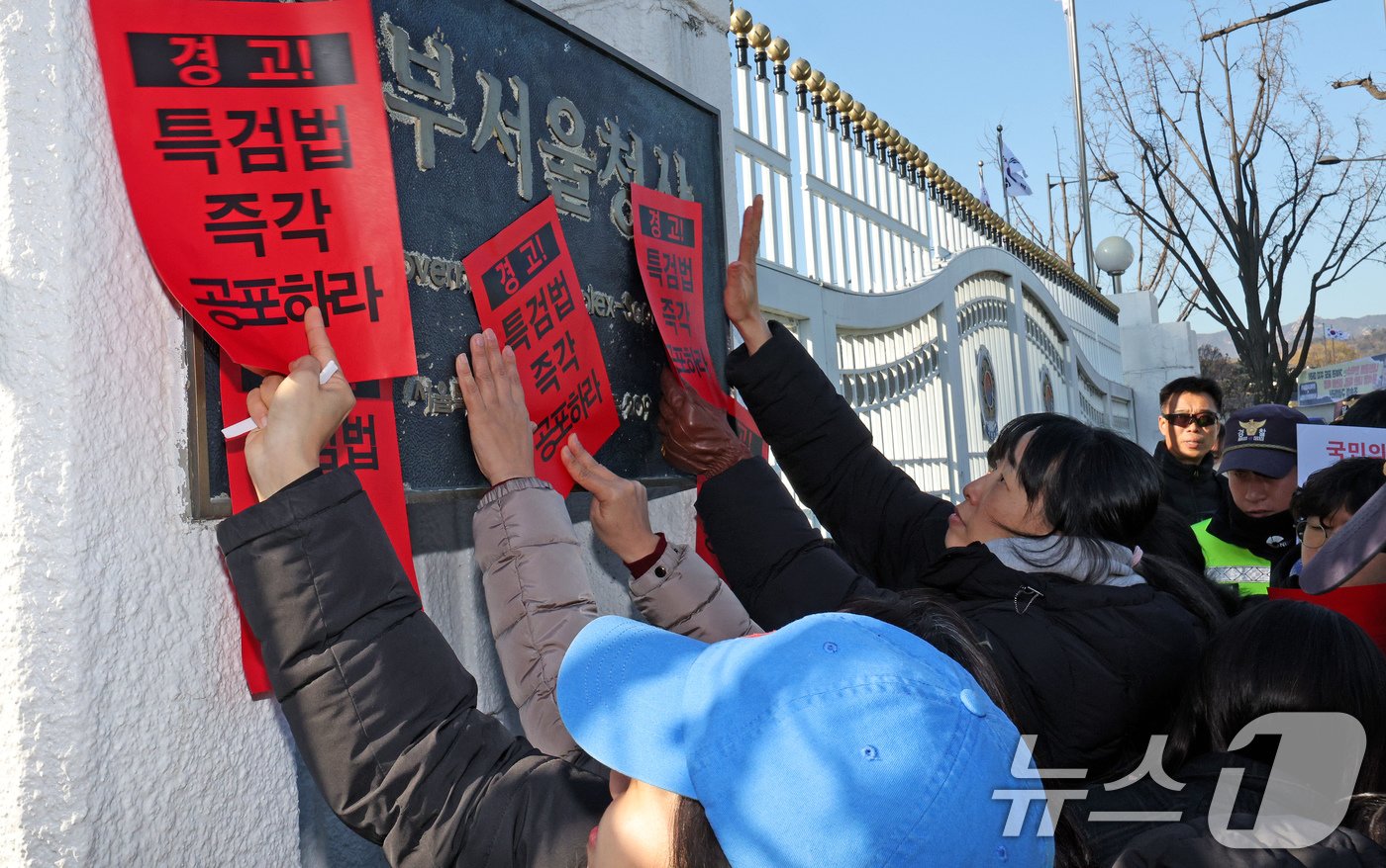 참여연대 회원들이 23일 오후 서울 종로구 정부서울청사에서 한덕수 대통령 권한대행 국무총리을 향해 내란 특검법 및 김건희 특검법 즉각 공포를 촉구하는 경고장을 현판에 부착하고 있다. 2024.12.23/뉴스1 ⓒ News1 장수영 기자