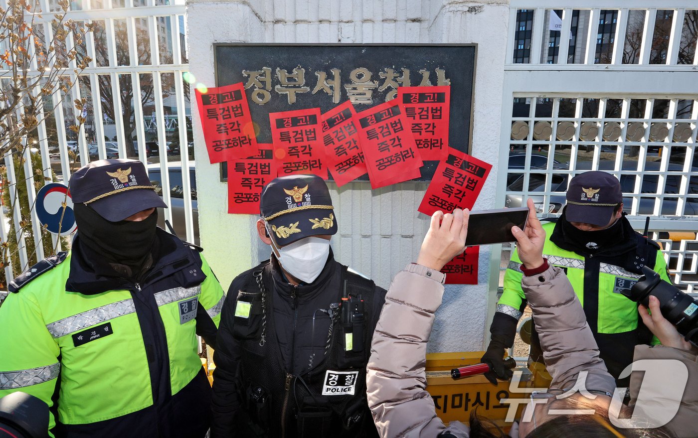 참여연대 회원들이 23일 오후 서울 종로구 정부서울청사에서 한덕수 대통령 권한대행 국무총리을 향해 내란 특검법 및 김건희 특검법 즉각 공포를 촉구하는 경고장을 현판에 부착하고 있다. 2024.12.23/뉴스1 ⓒ News1 장수영 기자