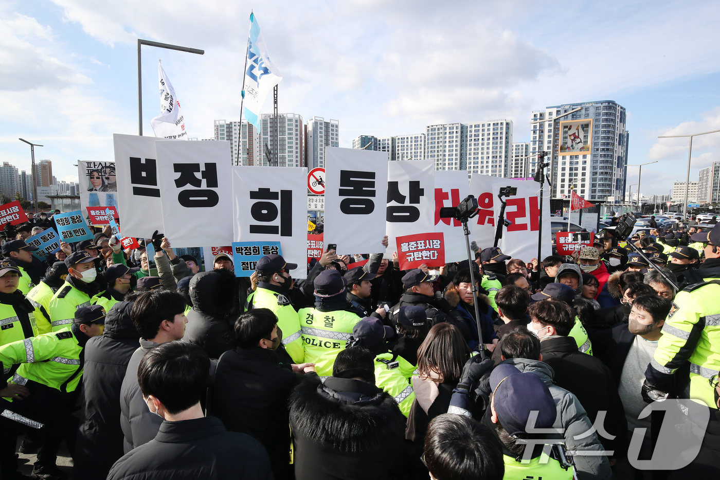 (대구=뉴스1) 공정식 기자 = 23일 오후 대구 동구 동대구역 광장에서 열린 '박정희 대통령 동상 제막식' 현장에 동상 건립을 반대하는 단체 회원들이 몰려 경찰과 대치하고 있다. …