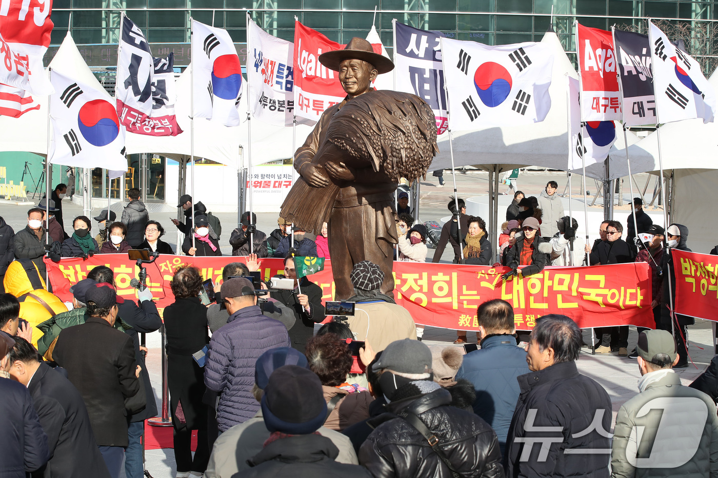 (대구=뉴스1) 공정식 기자 = 23일 오후 대구 동구 동대구역 광장에서 보수단체 회원들이 박정희 전 대통령 동상 주변에 몰려 환호하고 있다. 2024.12.23/뉴스1