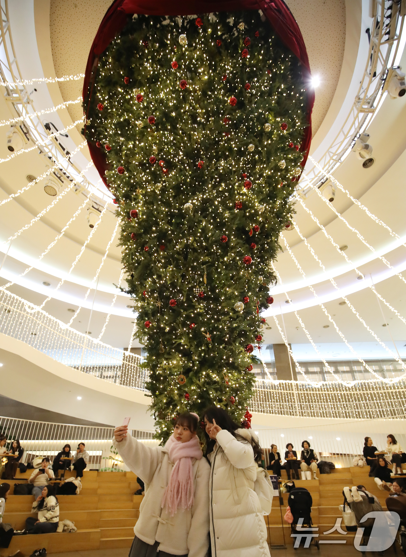 (부산=뉴스1) 윤일지 기자 = 크리스마스를 이틀 앞둔 23일 오후 부산진구 롯데백화점 부산본점 9층 엘아레나 광장을 찾은 시민들이 높이 7m 크기의 '거꾸로 트리'를 감상하며 사 …