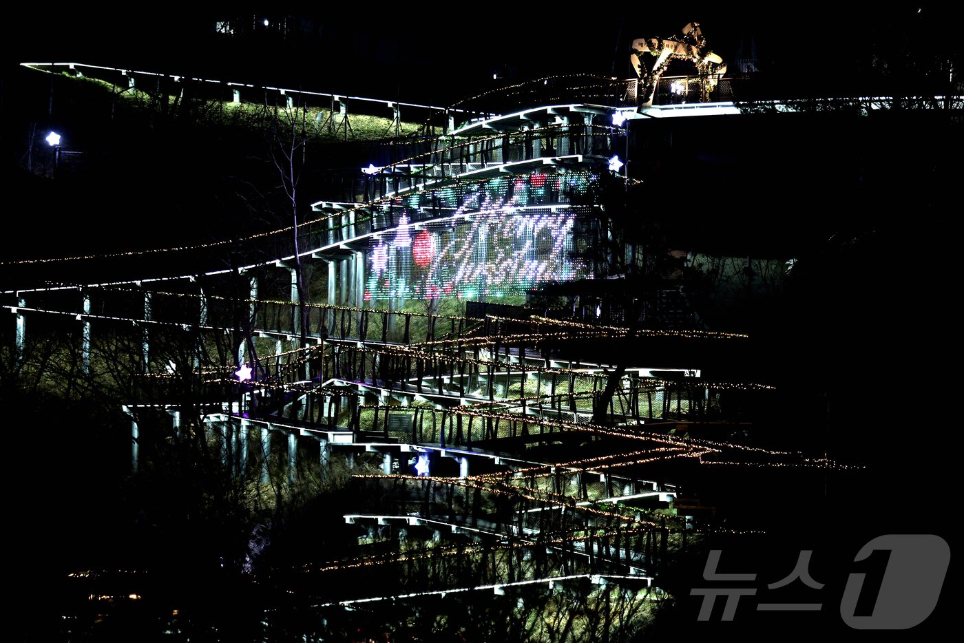 본문 이미지 - 크리스마스를 이틀 앞둔 23일 오후 경기 김포시 애기봉 평화생태공원 탐방로가 트리 모양으로 불을 밝히고 있다. 김포시는 1971년부터 매년 높이 18m 철탑을 트리로 꾸며 점등했지만 2014년 철탑 철거로 중단했으며 지난해부터 생태탐방로를 트리 모양으로 꾸며 점등하고 있다. 2024.12.23/뉴스1 ⓒ News1 신웅수 기자