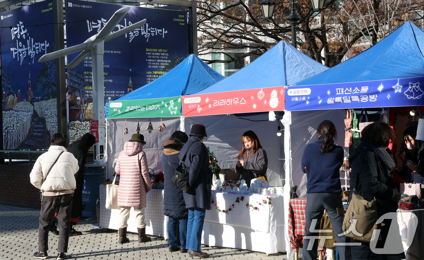 (서울=뉴스1) 김명섭 기자 = 24일 서울 명동성당 가톨릭회관 앞 광장에서 열린 '2024 명동, 겨울을 밝히다' 축제 성탄마켓에서 시민과 신자들이 수공예 성물, 생황 공예품 등 …