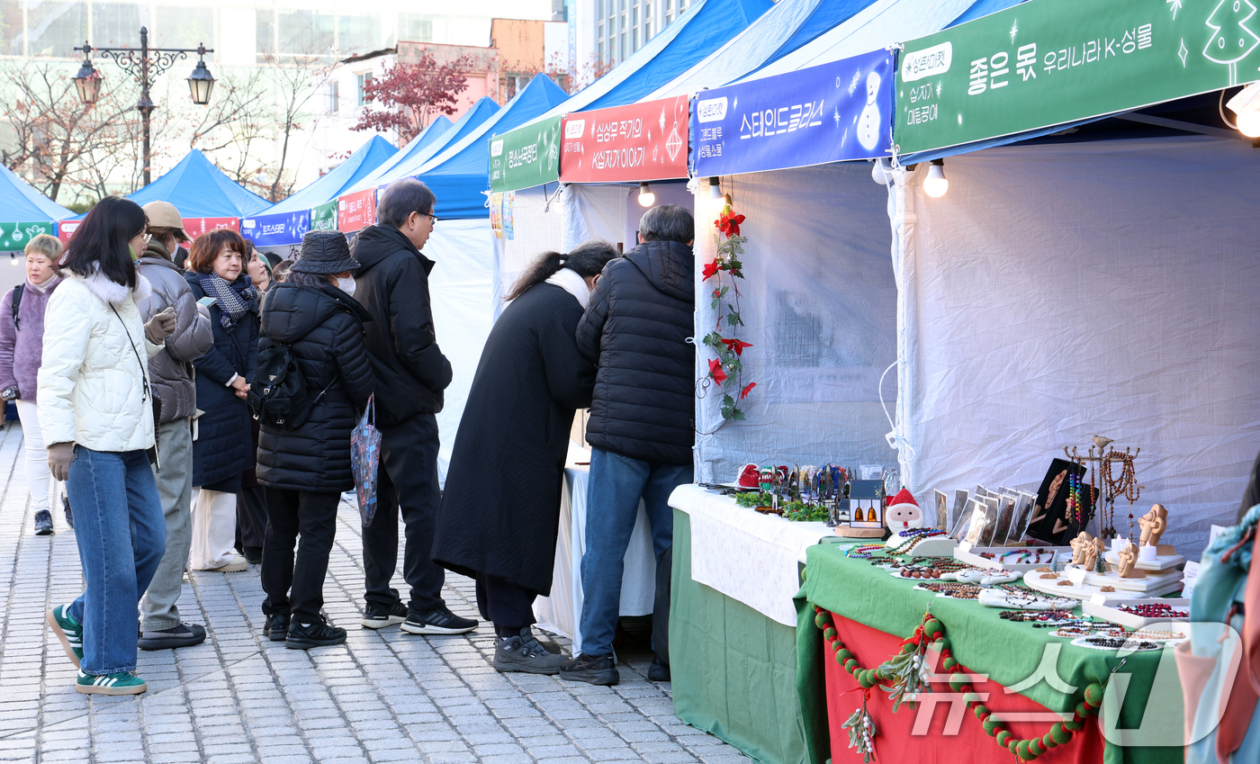 (서울=뉴스1) 김명섭 기자 = 24일 서울 명동성당 가톨릭회관 앞 광장에서 열린 '2024 명동, 겨울을 밝히다' 축제 성탄마켓에서 시민과 신자들이 수공예 성물, 생황 공예품 등 …