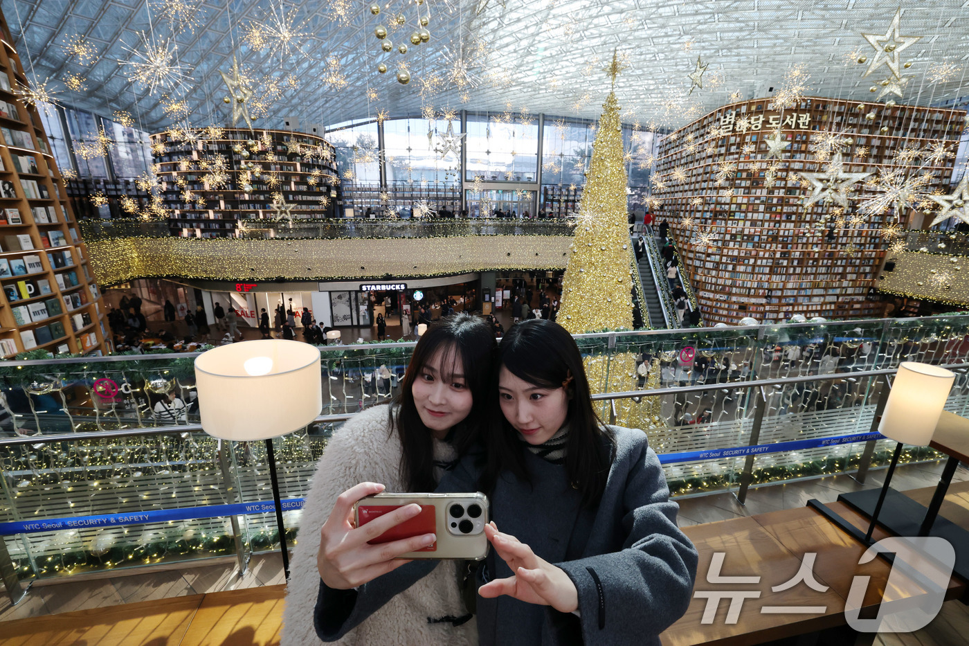 (서울=뉴스1) 박세연 기자 = 크리스마스 이브인 24일 서울 강남구 스타필드 코엑스몰 별마당도서관을 찾은 일본인 관광객이 대형 트리를 배경으로 기념사진을 찍고 있다. 2024.1 …