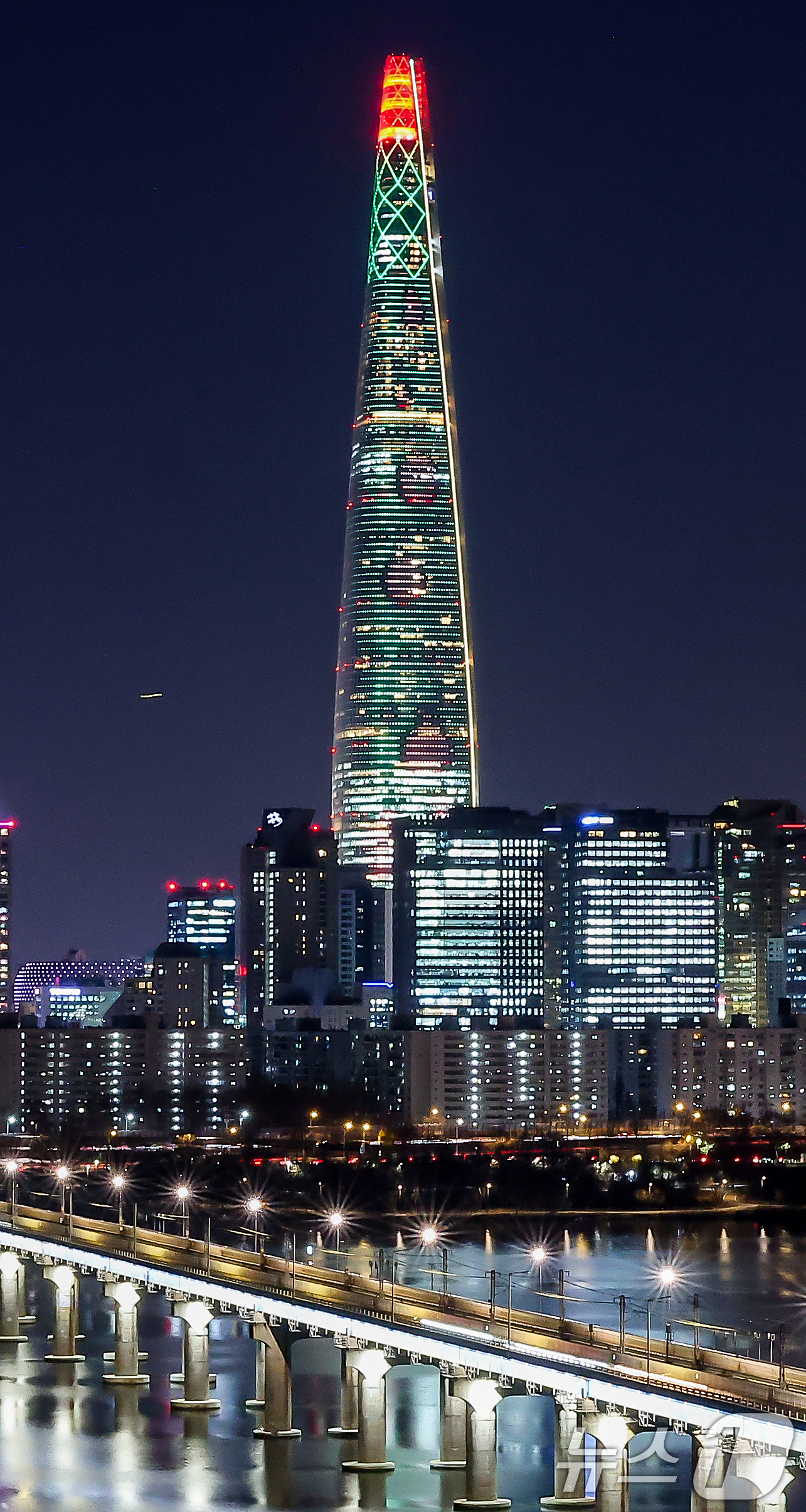 (서울=뉴스1) 김진환 기자 = 성탄절을 하루 앞둔 24일 오후 서울 송파구 롯데월드타워 외벽에 미디어 파사드 영상을 이용한 555m 높이의 초대형 크리스마스 장식이 불을 밝히고 …