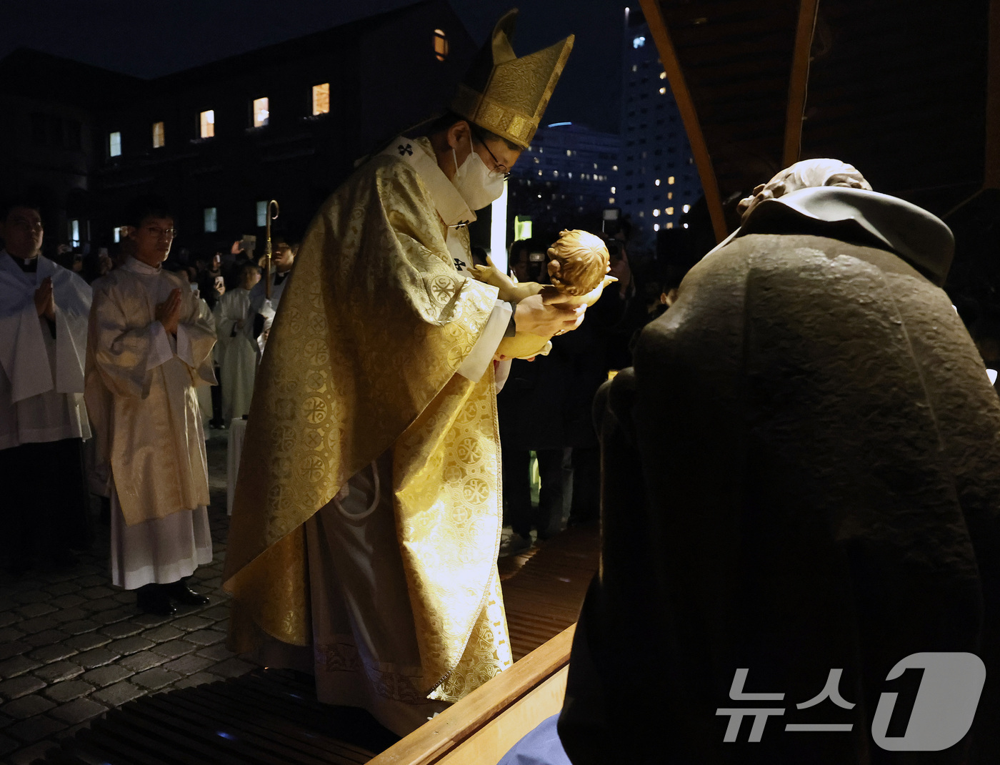 (서울=뉴스1) 구윤성 기자 = 천주교 서울대교구장 정순택 대주교가 25일 새벽 서울 중구 명동대성당 앞마당에서 아기 예수를 말 구유에 안치하는 '구유 예절' 의식을 행하고 있다. …