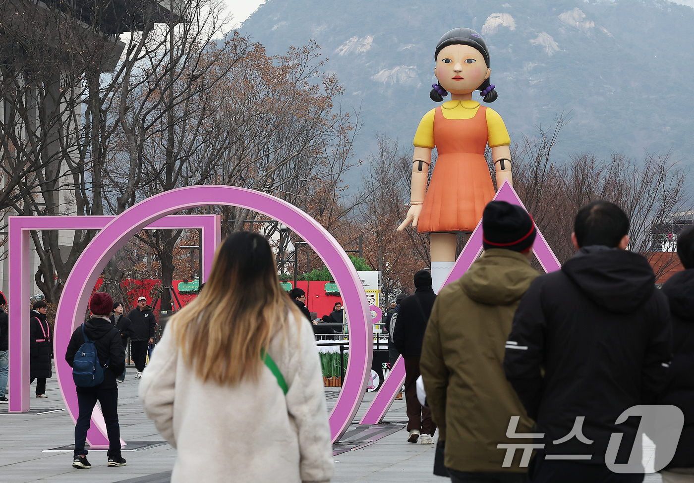 (서울=뉴스1) 김진환 기자 = 성탄절인 25일 서울 종로구 광화문광장에 설치된 넷플릭스 오리지널시리즈 '오징어게임2'의 '영희'의 대형 모형 앞으로 시민들이 지나고 있다.한편, …