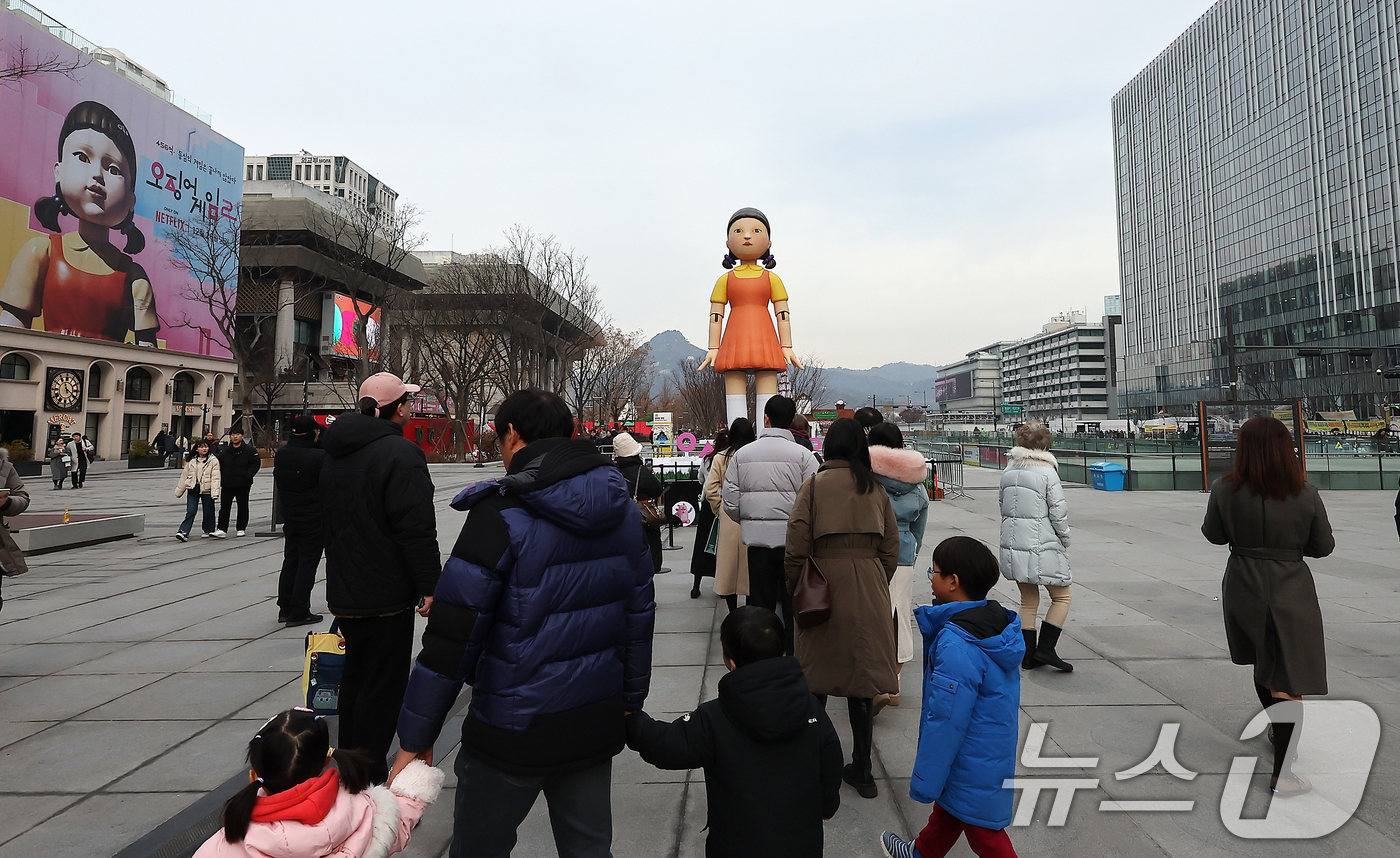 (서울=뉴스1) 김진환 기자 = 성탄절인 25일 서울 종로구 광화문광장을 찾은 시민들이 넷플릭스 오리지널시리즈 '오징어게임2'의 '영희'의 대형 모형 앞에서 추억을 남기고 있다.한 …