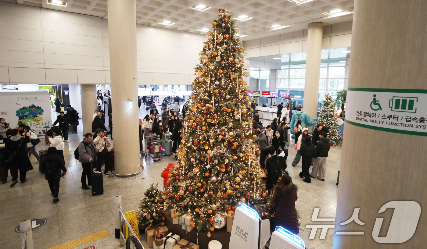 (제주=뉴스1) 오현지 기자 = 성탄절인 25일 오후 제주국제공항 국내선 도착 대합실에 설치된 대형 감귤 크리스마스 트리가 눈길을 끌고 있다. 2024.12.25/뉴스1