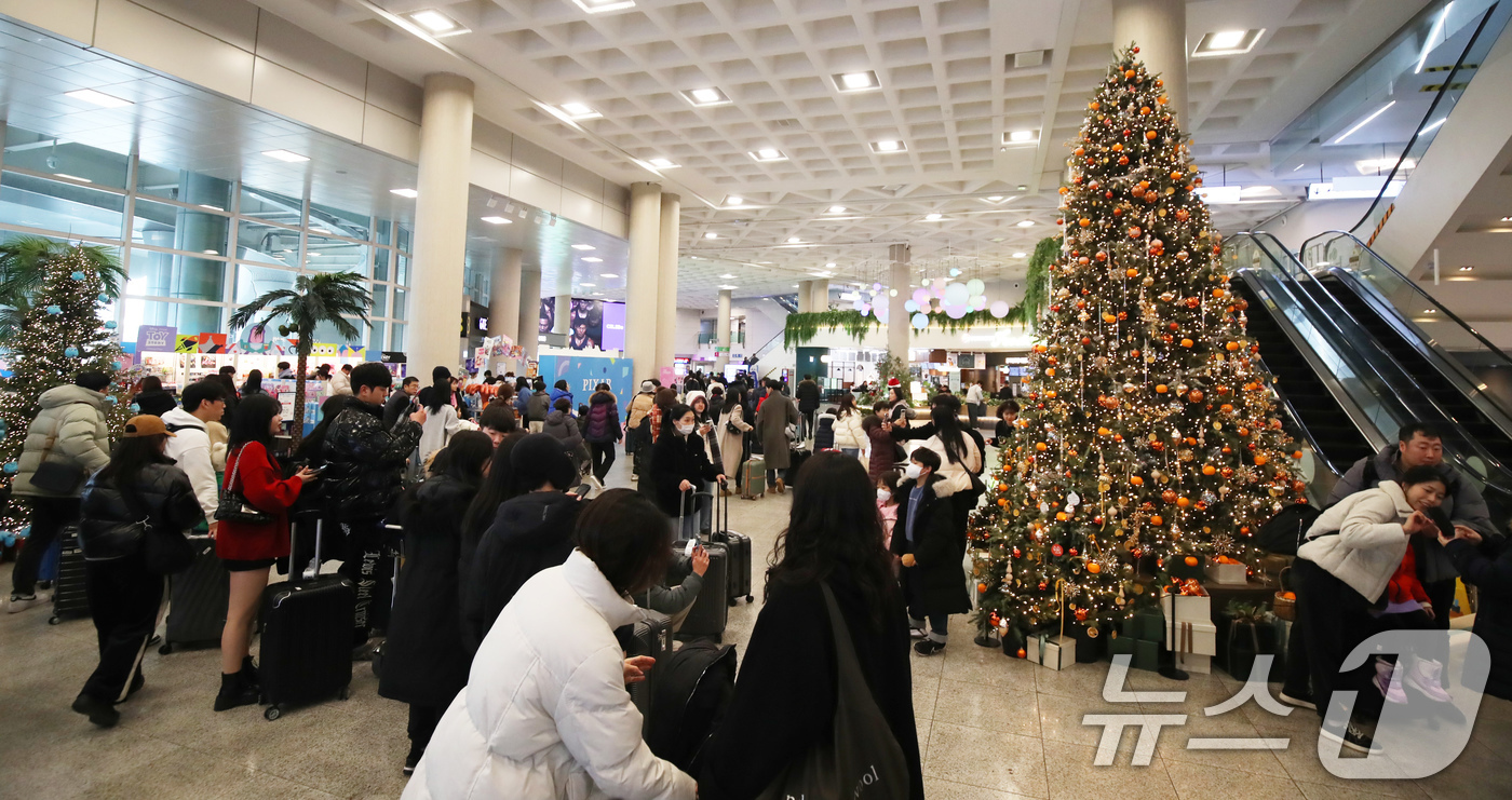 (제주=뉴스1) 오현지 기자 = 성탄절인 25일 오후 제주국제공항 국내선 도착 대합실에 설치된 대형 감귤 크리스마스 트리가 눈길을 끌고 있다. 2024.12.25/뉴스1