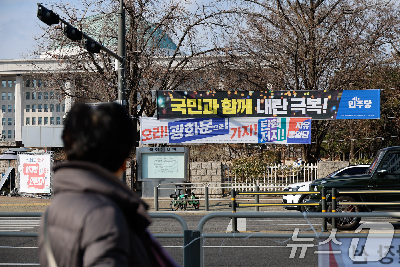 (서울=뉴스1) 안은나 기자 = 탄핵 정국 속 윤석열 대통령이 공조수사본부 소환에 불응한 25일 서울 여의도 국회의사당 앞에 더불어민주당과 자유통일당이 내건 현수막이 걸려 있다. …