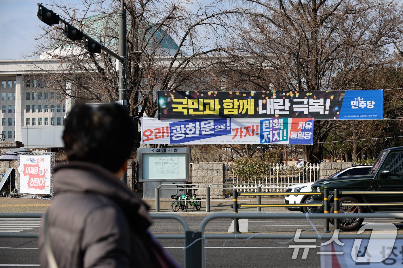 탄핵 정국 속 윤석열 대통령이 공조수사본부 소환에 불응한 25일 서울 여의도 국회의사당 앞에 더불어민주당과 자유통일당이 내건 현수막이 걸려 있다. 2024.12.25/뉴스1 ⓒ News1 안은나 기자