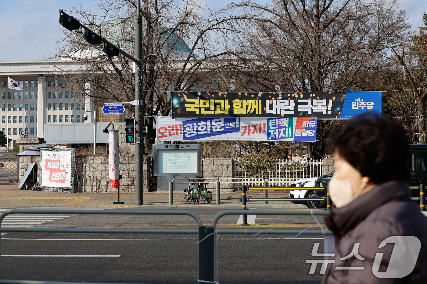 (서울=뉴스1) 안은나 기자 = 탄핵 정국 속 윤석열 대통령이 공조수사본부 소환에 불응한 25일 서울 여의도 국회의사당 앞에 더불어민주당과 자유통일당이 내건 현수막이 걸려 있다. …