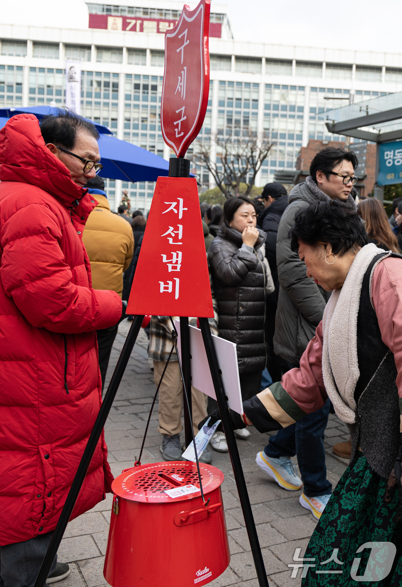 (서울=뉴스1) 이승배 기자 = 성탄절인 25일 오후 서울 중구 명동거리에서 한 시민이 구세군 자선냄비에 기부하고 있다. 2024.12.25/뉴스1