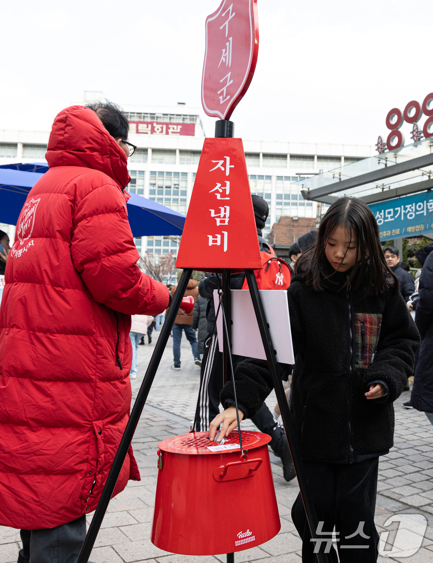 (서울=뉴스1) 이승배 기자 = 성탄절인 25일 오후 서울 중구 명동거리에서 한 어린이가 구세군 자선냄비에 기부를 하고 있다. 2024.12.25/뉴스1