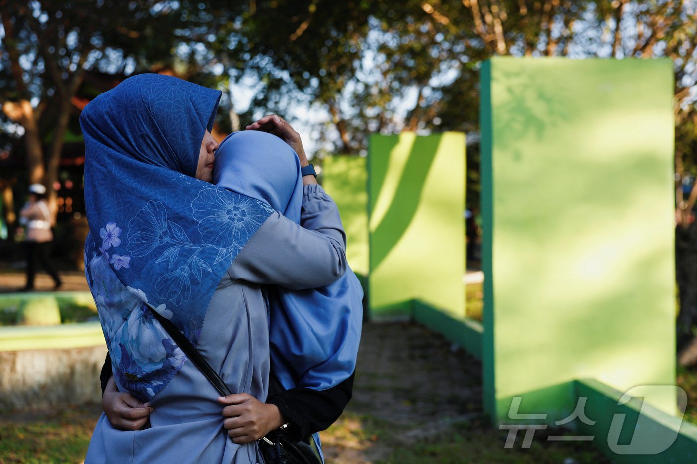 본문 이미지 - 20년 전 인도양에서 발생한 쓰나미로 희생된 22만 명의 죽음을 기리기 위한 추도식이 26일&#40;현지시간&#41; 인도네시아에서 엄수됐다. 사진은 반다 아체에 있는 공동 묘지를 찾은 여성들의 모습. 2024.12.26 ⓒ 로이터=뉴스1 ⓒ News1 최종일 기자