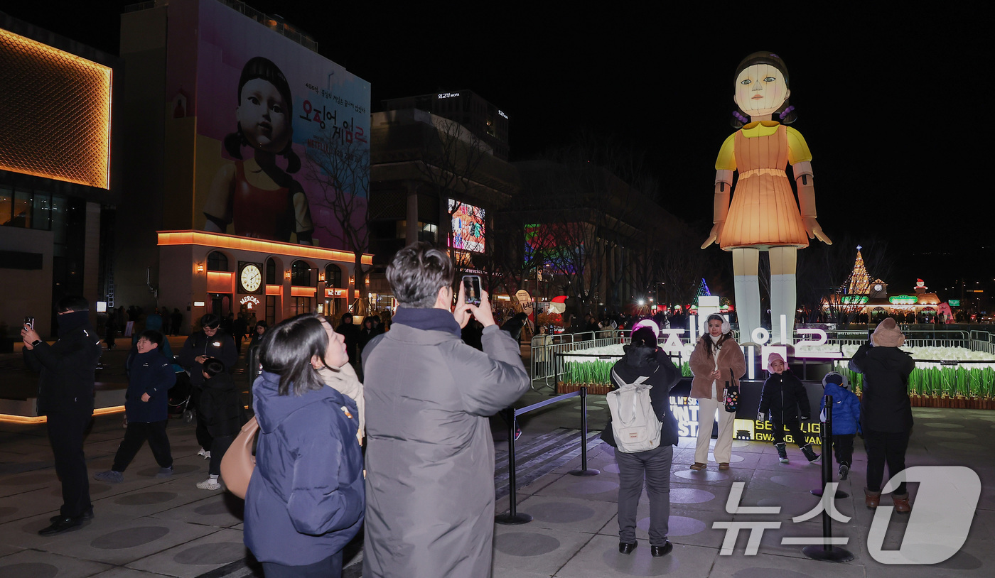 (서울=뉴스1) 김성진 기자 = 넷플릭스의 '오징어게임 시즌2'가 공개된 26일 오후 서울 광화문광장에 설치된 '영희' 조형물 앞에서 시민들이 기념촬영을 하고 있다. 2024.12 …