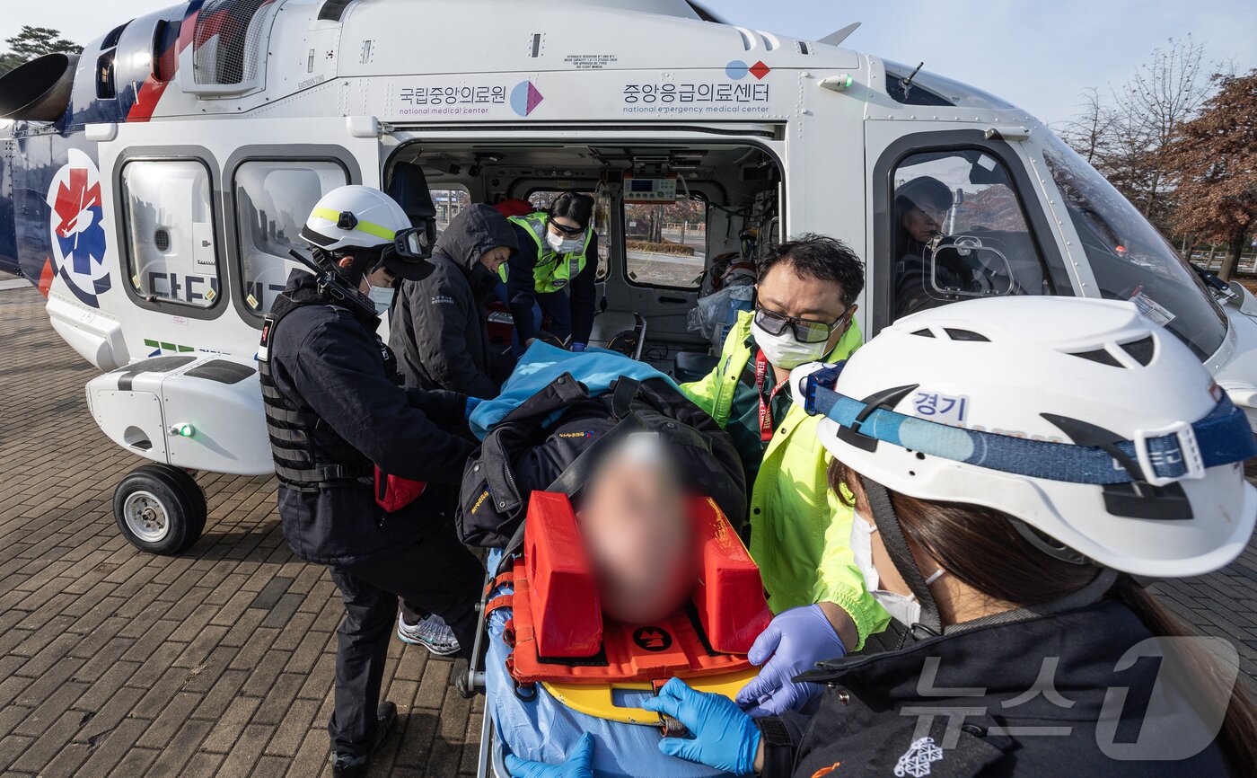 본문 이미지 - 인계점에서 만난 환자를 닥터헬기로 옮기고 있다.. ⓒ News1 이재명 기자