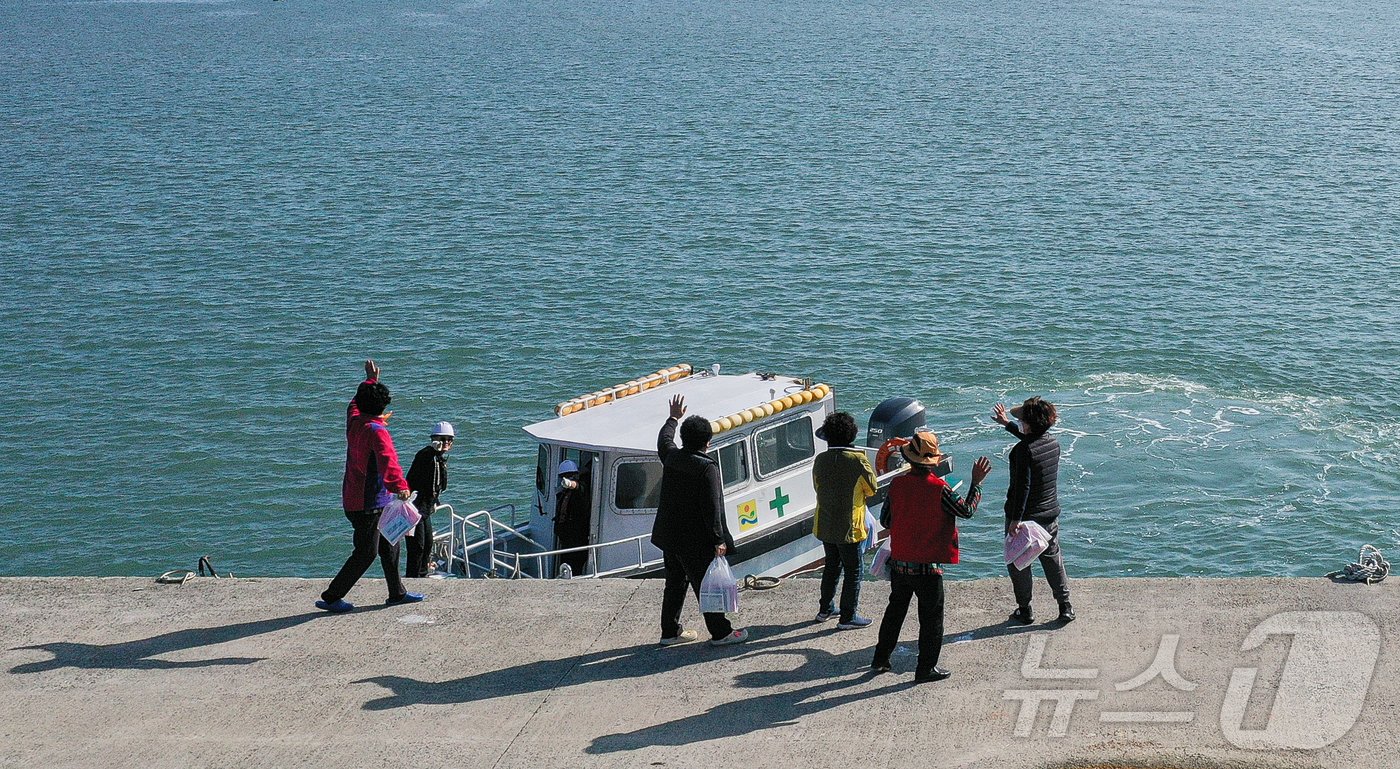 진료를 마친 섬마을 주민들이 수송선 직원들에게 인사하고 있다. ⓒ News1 이재명 기자