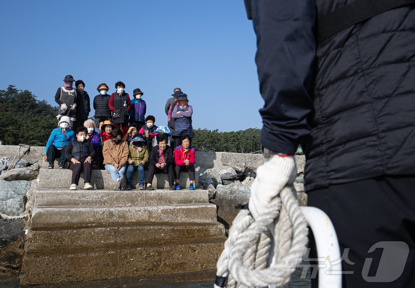 섬마을 주민들이 옹기종기 모여 앉아 병원선 &#39;전남 511호&#39;로 향하는 수송선을 기다리고 있다. ⓒ News1 이재명 기자