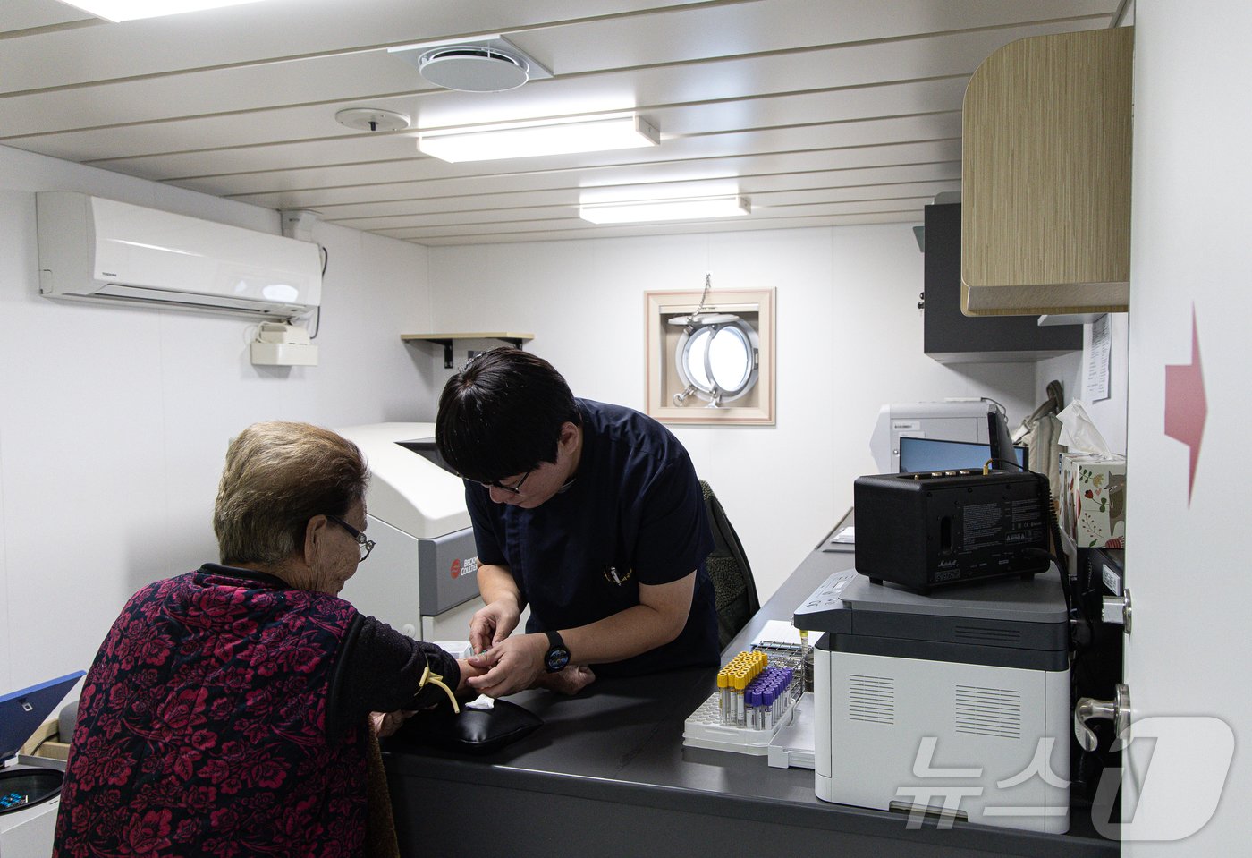 본문 이미지 - 임상병리사가 섬마을 주민의 혈액을 채취하고 있다. 병원선에서 혈액 검사까지 가능하다. ⓒ News1 이재명 기자