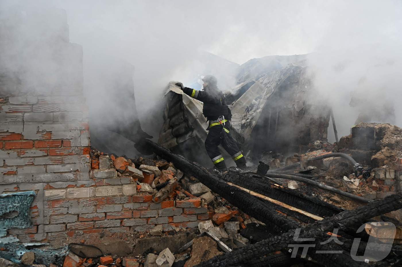 (하르키우 AFP=뉴스1) 우동명 기자 = 25일(현지시간) 우크라이나 하르키우에서 러시아 군의 드론 공격을 받은 주택을 소방대원이 진화 작업을 하고 있다. 2024.12.27ⓒ …