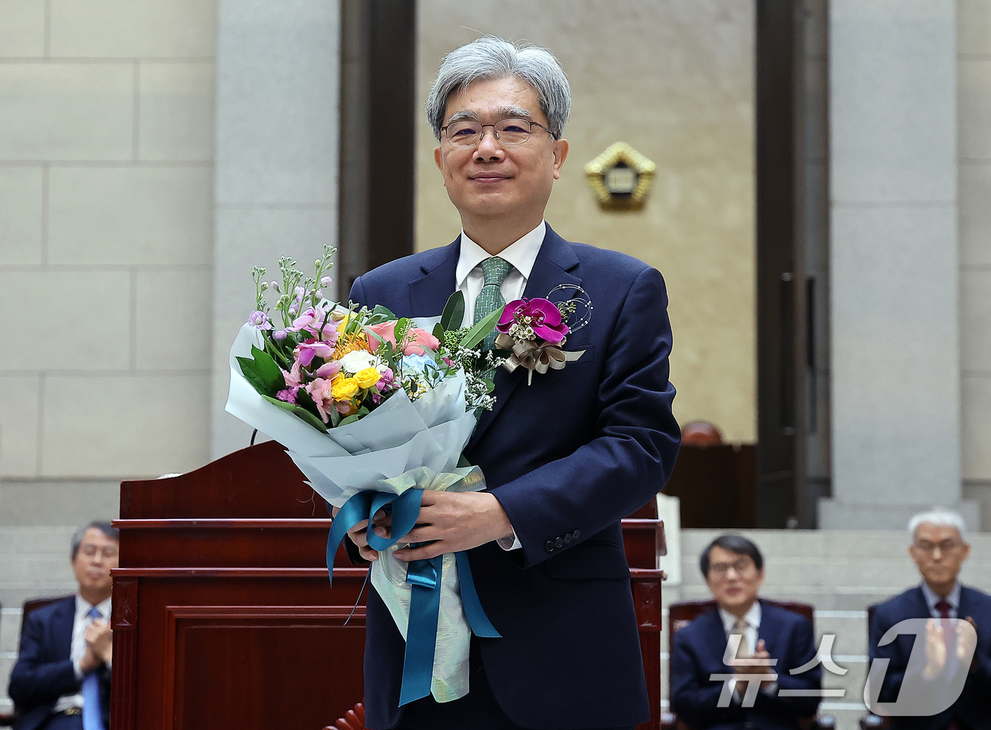 (서울=뉴스1) 김진환 기자 = 김상환 대법관이 27일 오전 서울 서초구 대법원에서 열린 퇴임식에서 꽃다발을 받은 뒤 기념 촬영을 하고 있다. 김상환 대법관은 대전 출신으로 서울중 …