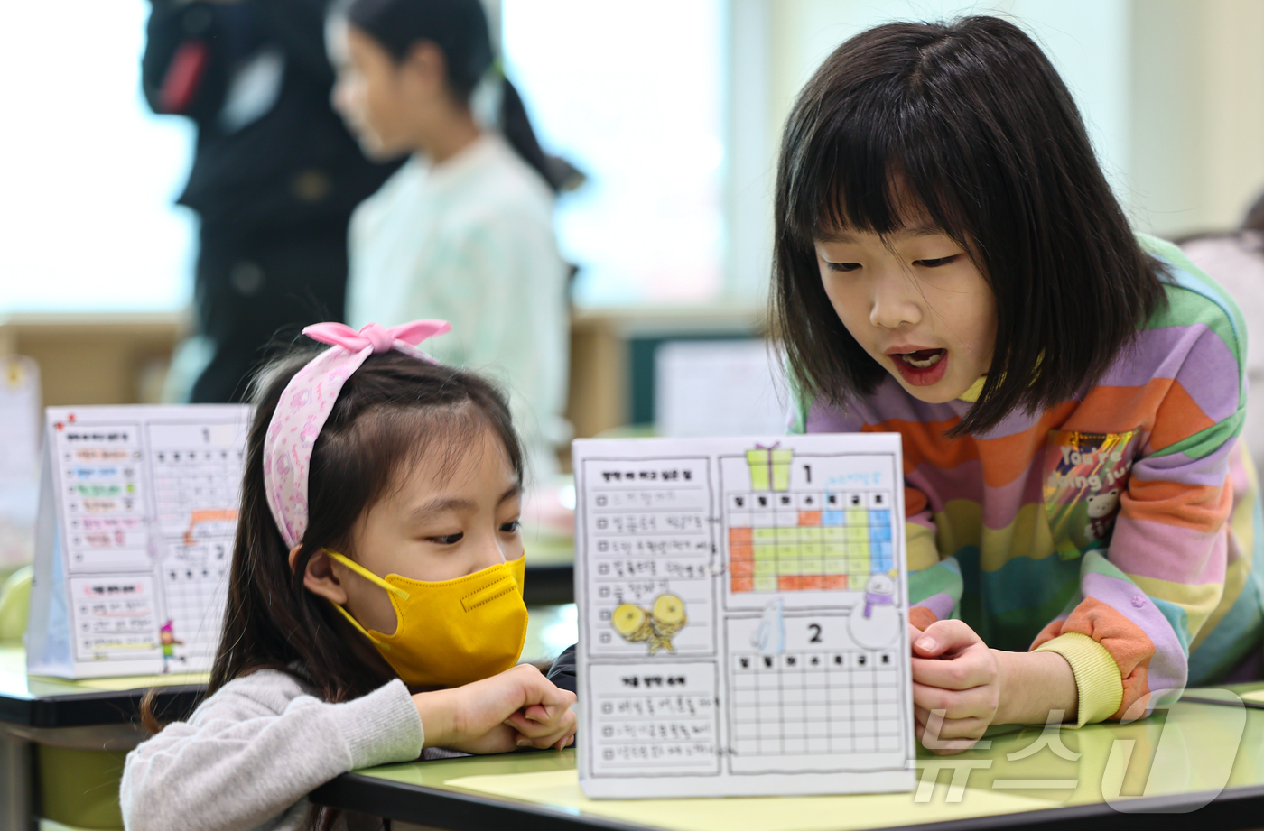 (서울=뉴스1) 김도우 기자 = 27일 서울 구로구 개봉초등학교에서 열린 겨울방학식에서 3학년 학생들이 서로의 방학 계획표를 보며 이야기를 나누고 있다. 2024.12.27/뉴스1 …