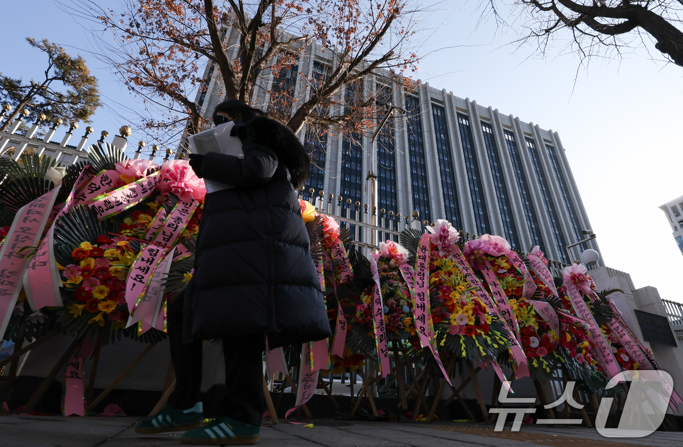 (서울=뉴스1) 허경 기자 = 27일 서울 종로구 정부서울청사 외벽에 한덕수 대통령 권한대행 국무총리를 응원하는 화환이 놓여져 있다. 국회는 오늘 본회의를 열고 한덕수 대통령 권한 …