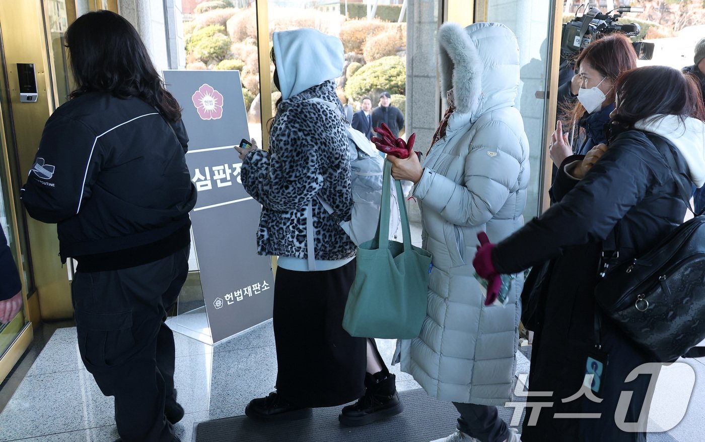 27일 서울 종로구 헌법재판소에서 열린 윤석열 대통령 탄핵심판 사건 변론준비기일에서 방청권을 받은 시민들이 소심판정으로 들어가기 위해 줄을 서고 있다. 헌법재판소에 따르면 소심판정 방청석 9석에 대한 헌재 홈페이지 온라인 방청 신청 결과 총 20264명이 응모해 경쟁률 2251.5대 1을 기록했다. &#40;공동취재&#41; 2024.12.27/뉴스1 ⓒ News1 박지혜 기자