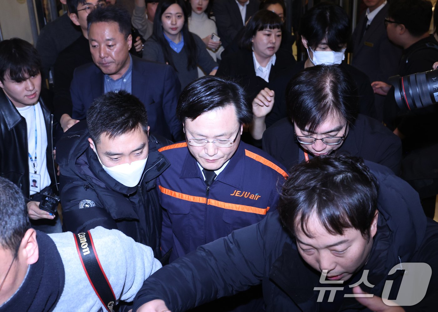 본문 이미지 - 김이배 제주항공 대표가 29일 오후 서울 강서구 메이필드 호텔에 마련된 임시 프레스센터에서 무안국제공항 여객기 사고 관련 브리핑을 마치고 취재진에 둘러싸여 퇴장 하고 있다. 2024.12.29/뉴스1 ⓒ News1 송원영 기자