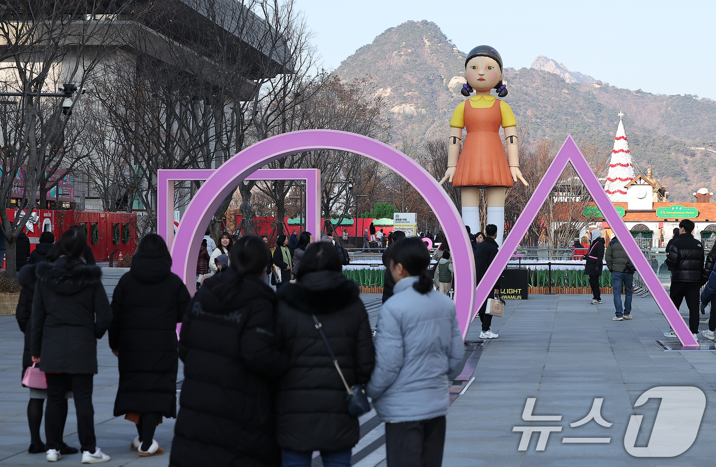 (서울=뉴스1) 김진환 기자 = 29일 오후 서울 종로구 광화문광장을 찾은 관광객들이 넷플릭스 오리지널시리즈 '오징어게임2'의 '영희'의 대형 조형물 앞에서 기념 촬영을 하고 있다 …