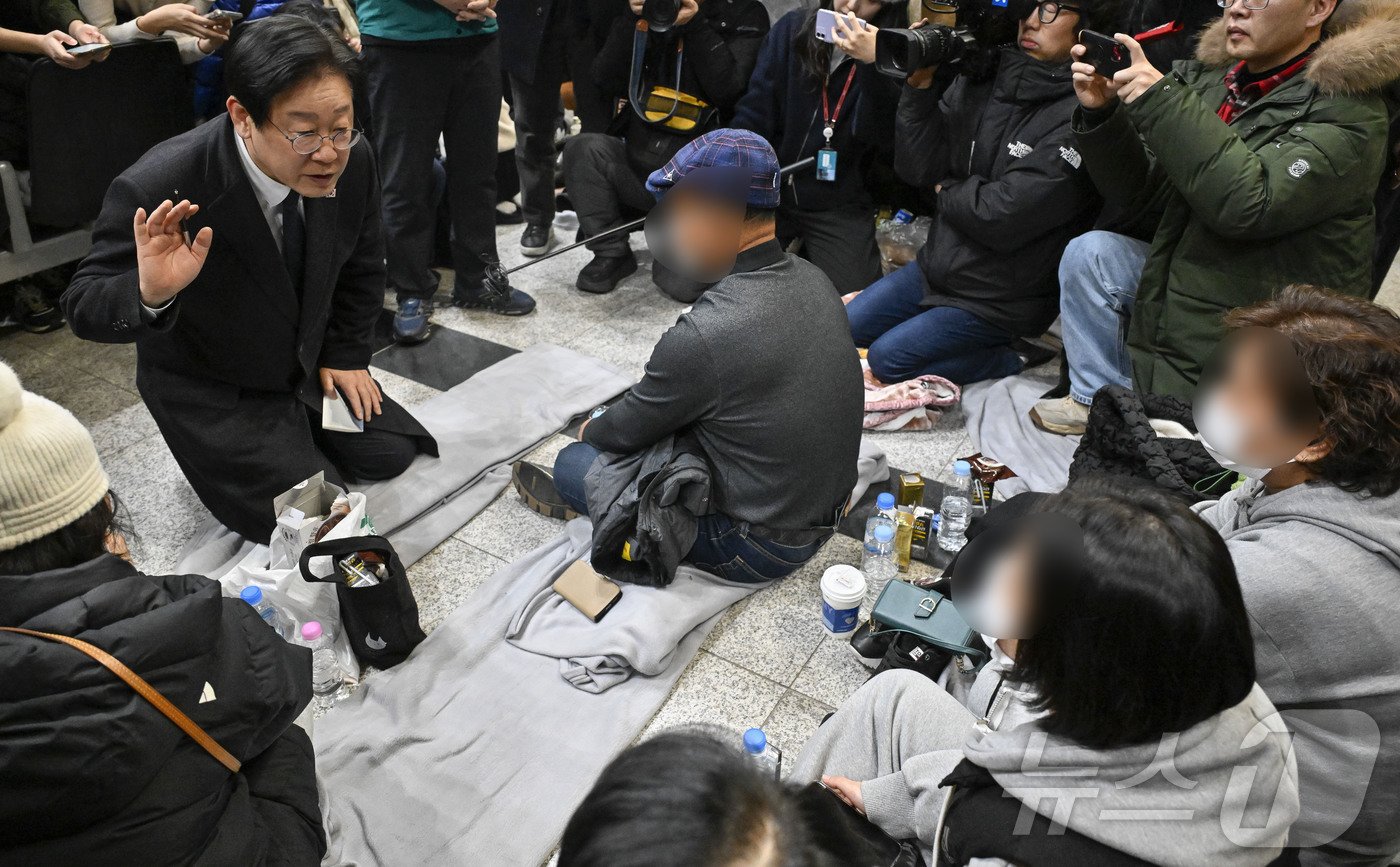 본문 이미지 - 이재명 더불어민주당 대표가 29일 오후 전남 무안국제공항에서 제주항공 여객기 사고 탑승객 가족들을 위로하고 있다. (공동취재) 2024.12.29/뉴스1 ⓒ News1 김태성 기자