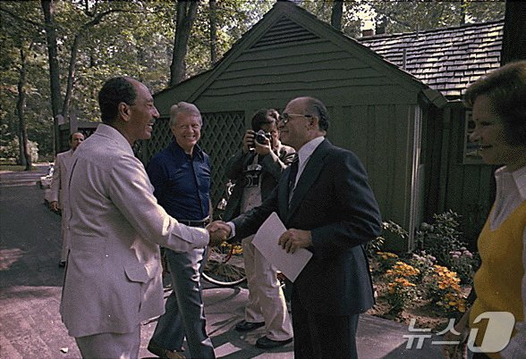 본문 이미지 - 제39대 미국 대통령을 지낸 지미 카터 전 대통령이 29일&#40;현지시간&#41; 향년 100세의 나이로 별세했다. 사진은 1978년 9월 7일 메릴랜드 캠프 데이비드에서 카터 당시 미국 대통령&#40;가운데&#41;이 지켜보는 가운데 안와르 사다트 당시 이집트 대통령과 메나헴 베긴 당시 이스라엘 총리가 처음으로 인사하는 모습. ⓒ 로이터=뉴스1 ⓒ News1 최종일 기자