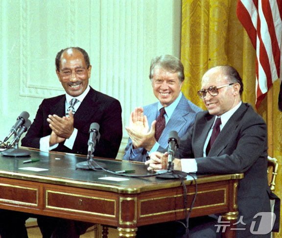 본문 이미지 - &#40;왼쪽부터&#41; 안와르 사다트 당시 이집트 대통령, 지미 카터 당시 미국 대통령, 메나헴 베긴 당시 이스라엘 총리가 미국 워싱턴DC 백악관에 모여 이집트와 이스라엘 간 평화협정인 캠프 데이비드 협정에 서명하고 있다. 1978.09.17 ⓒ 로이터=뉴스1 ⓒ News1 정지윤 기자