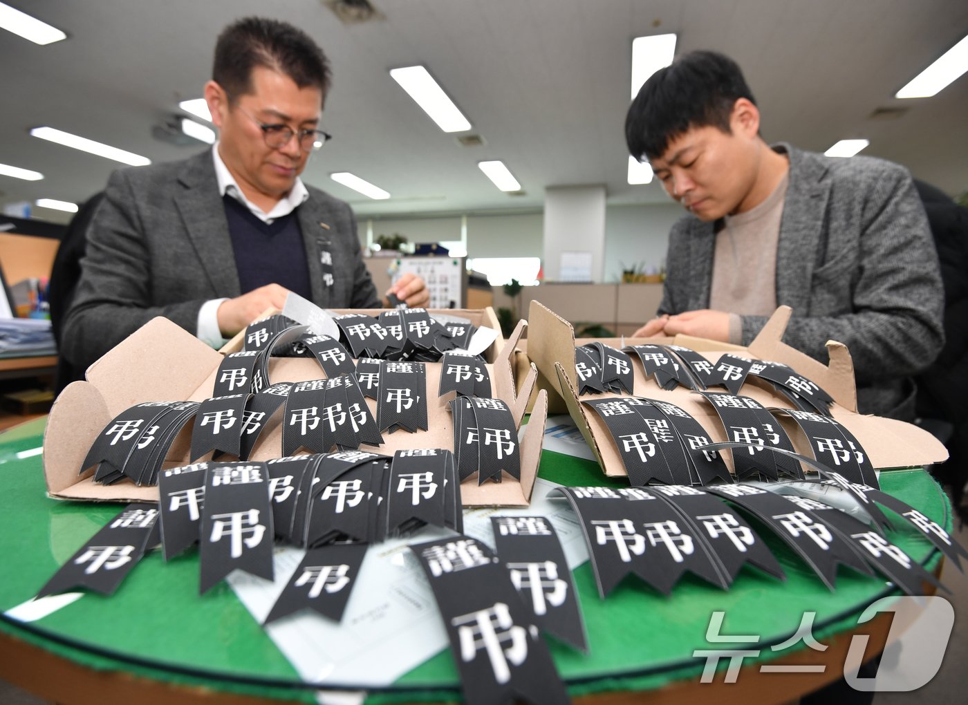 30일 경북 포항시청에서 공무원들이 전남 무안 제주항공 여객기 사고로 목숨을 잃은 분들의 명복을 빌기 위해 추모 리본을 준비하고 있다. 포항시는 시 소속 모든 공무원들과 함께 아픔을 나누기 위해 추모리본을 배부했다. 2024.12.30/뉴스1 ⓒ News1 최창호 기자