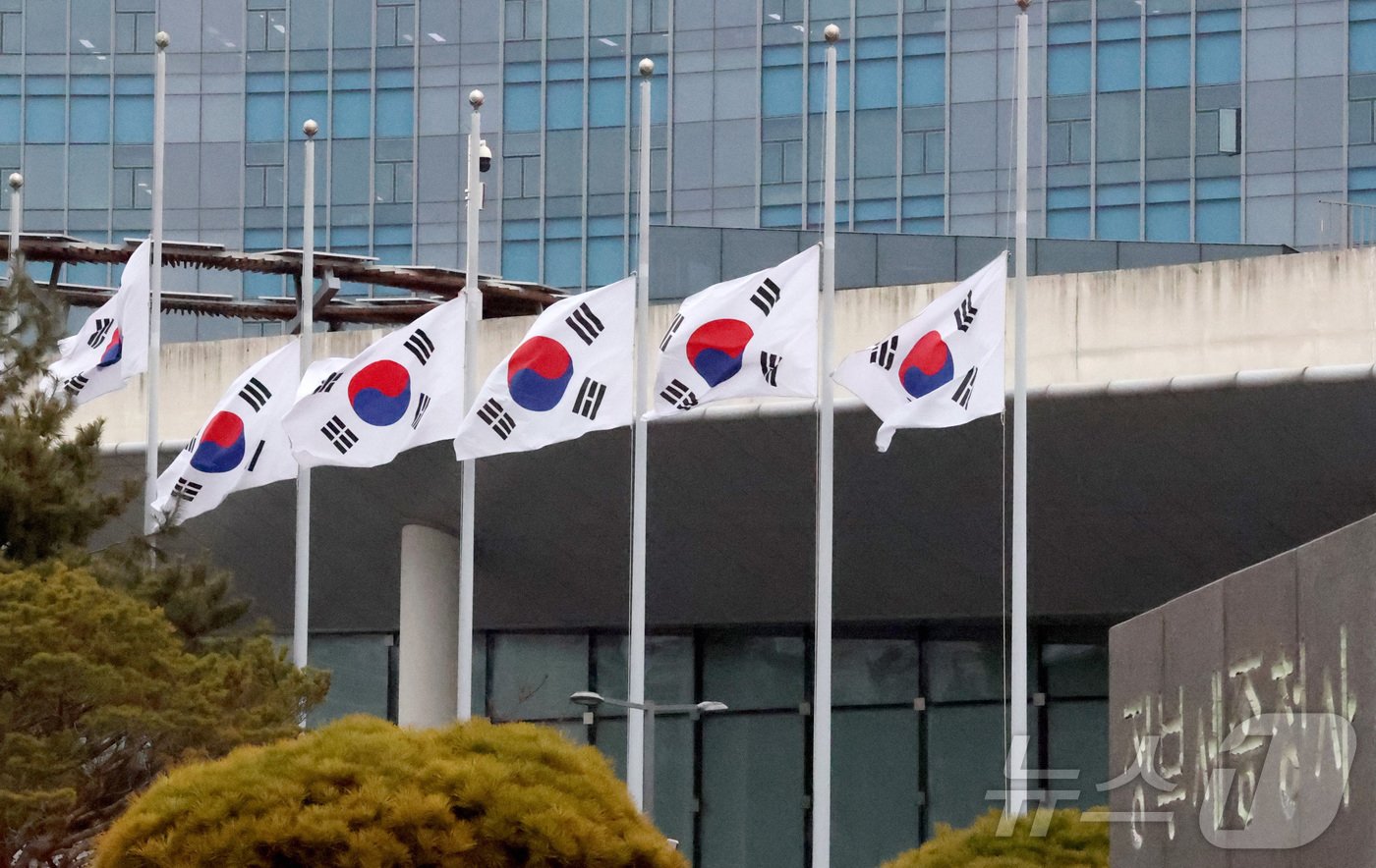 본문 이미지 - 30일 세종시 정부세종청사에 전남 무안국제공항에서 발생한 제주항공 사고 희생자를 애도하는 조기&#40;弔旗&#41;가 걸려 있다. 정부는 1월 4일까지 7일간의 국가애도기간에 전 부처와 지방자치단체 및 공공기관들이 조기&#40;弔旗&#41;를 게양하고, 공직자들은 애도 리본을 착용하게 되며 전국 17개 시도에 합동분향소를 운영한다고 밝혔다. 2024.12.30/뉴스1 ⓒ News1 김기남 기자