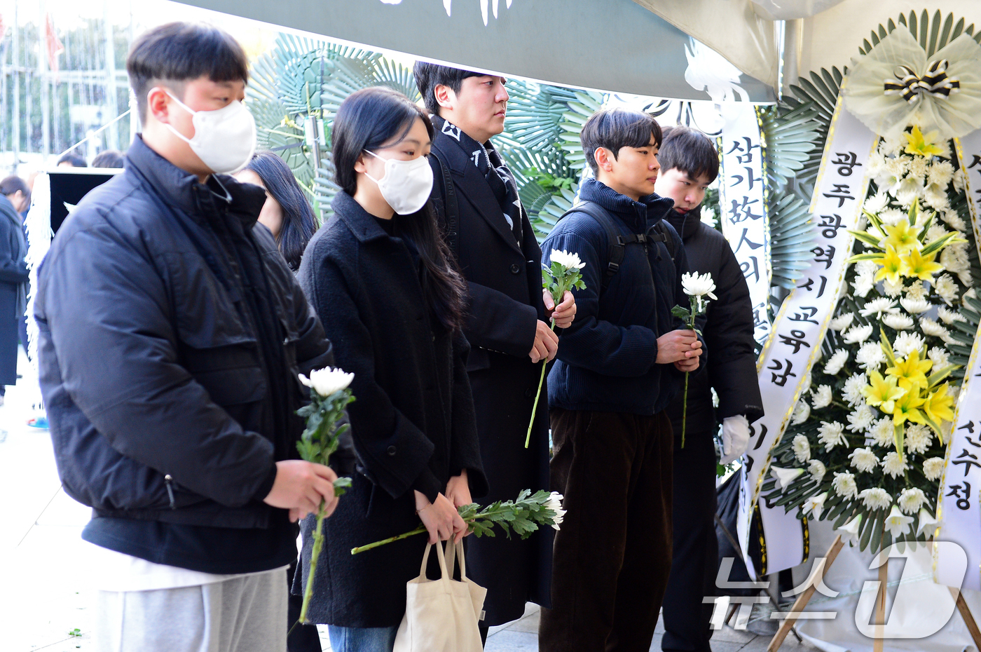 (광주=뉴스1) 이승현 기자 = 30일 광주 동구 5·18민주광장에 설치된 제주항공 여객기 참사 희생자 합동분향소에서 시민들이 국화꽃을 들고 추모 순서를 기다리고 있다. 2024. …