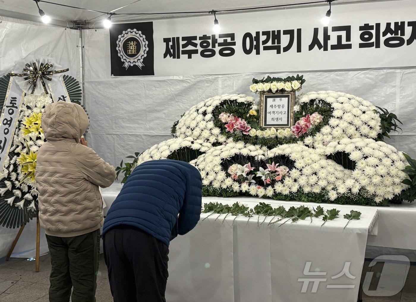 본문 이미지 - 30일 경남 통영시 강구안 문화마당에 마련된 제주항공 참사 합동분향소에서 희생자들을 기리고 있는 시민.2024.12.30/뉴스1 강미영기자