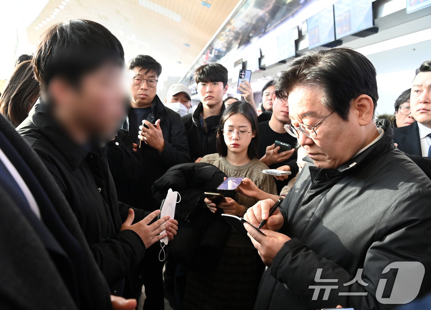 이재명 더불어민주당 대표가 31일 오전 전남 무안군 무안국제공항 터미널을 찾아 제주항공 여객기 사고 희생자 유가족을 위로하며 요구사항을 수첩에 적고 있다. &#40;공동취재&#41; 2024.12.31/뉴스1 ⓒ News1 김성진 기자